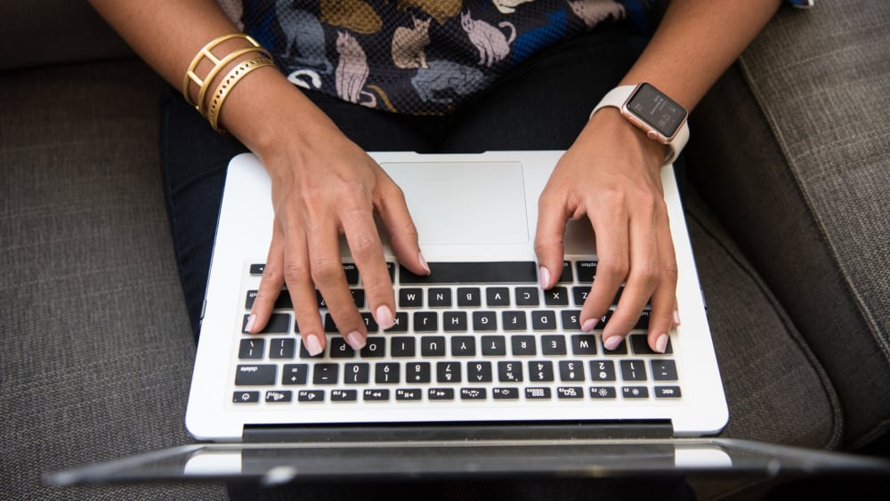 Woman writing sales copy using laptop